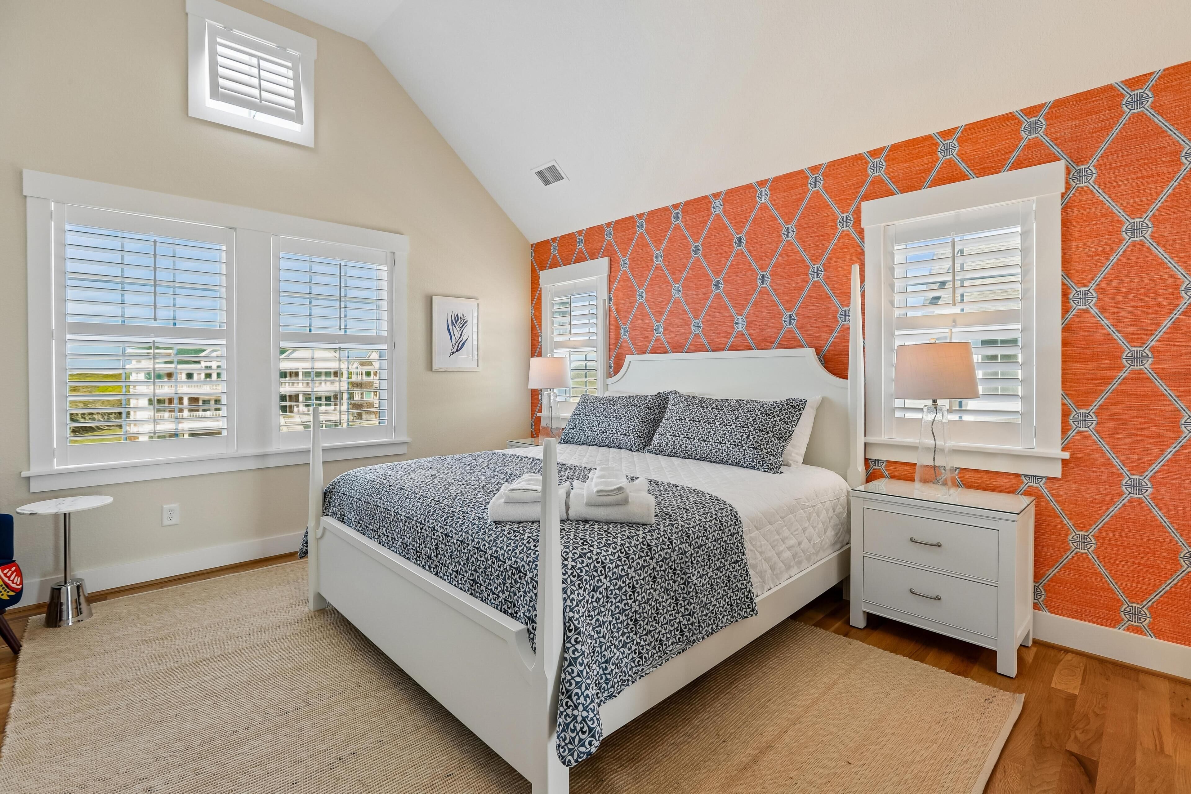 A bedroom with a bed, nightstands, and a window with blinds.