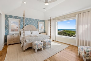 Quarto com cama de dossel, vista para o oceano e varanda.