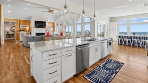 A modern kitchen with white cabinetry, a large island, and pendant lighting. - Fearing -- Brand New Oceanfront -- Ready for 2026! (Corolla)