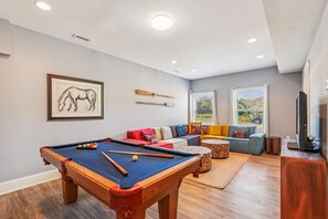 A pool table with pool cues, a sofa with colorful cushions, and a framed horse painting on the wall. - Wild Horses -- Gorgeous Pet Friendly home in Corolla Bay (Corolla)