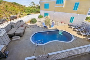 A backyard with a swimming pool, lounge chairs, and a barbecue area. - Wild Horses -- Gorgeous Pet Friendly home in Corolla Bay (Corolla)