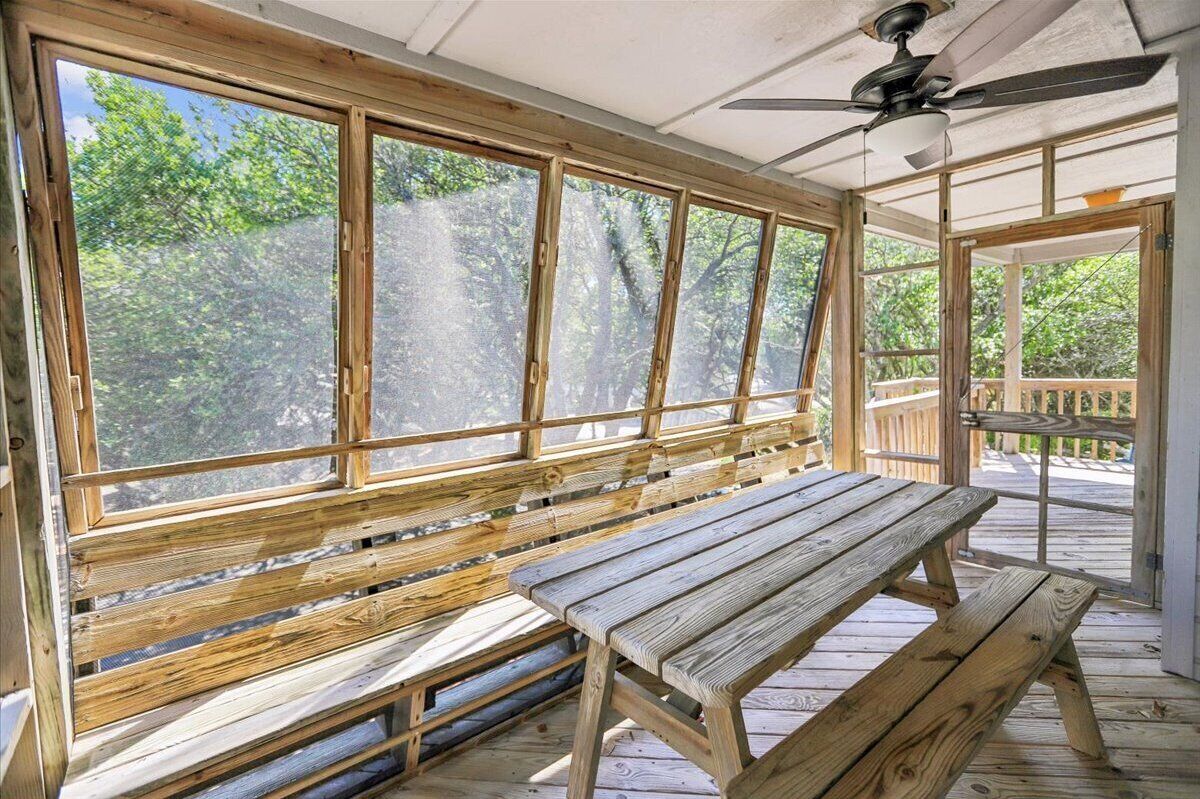 A wooden deck with a bench and a ceiling fan.