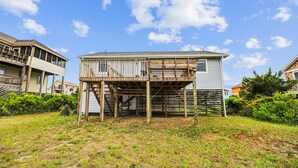 A two-story house with a wooden deck and a staircase leading to the upper floor. - Herons Return -- Flexible Arrival and Stay Dates Year Round (Kitty Hawk)