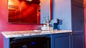 Una cocina moderna con horno empotrado, cafetera y encimera con diversos objetos.