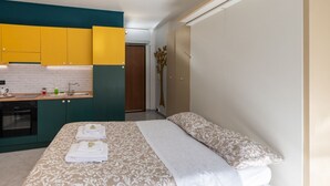 Een slaapkamer met een bed, nachtkastje en een raam.