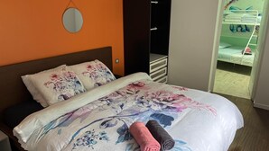 Un dormitorio con cama, armario y puerta que da a un balcón.
