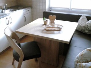 Eine Küche mit Esstisch, Spüle und Fenster.