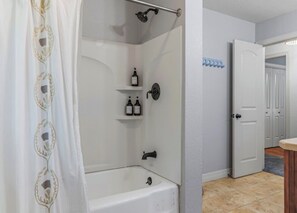Een douche, handdoeken, zeep, toiletpapier