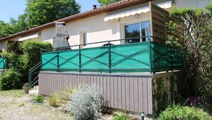 A two-story house with a balcony, surrounded by greenery and trees. - Gite in the heart of the Périgord Noir (Tamniès)
