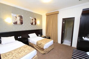 A hotel room with two beds, a minibar, a desk, and a door leading to a bathroom. - Al Rifaa Al Aziziyah Hotel Makkah (Makkah)