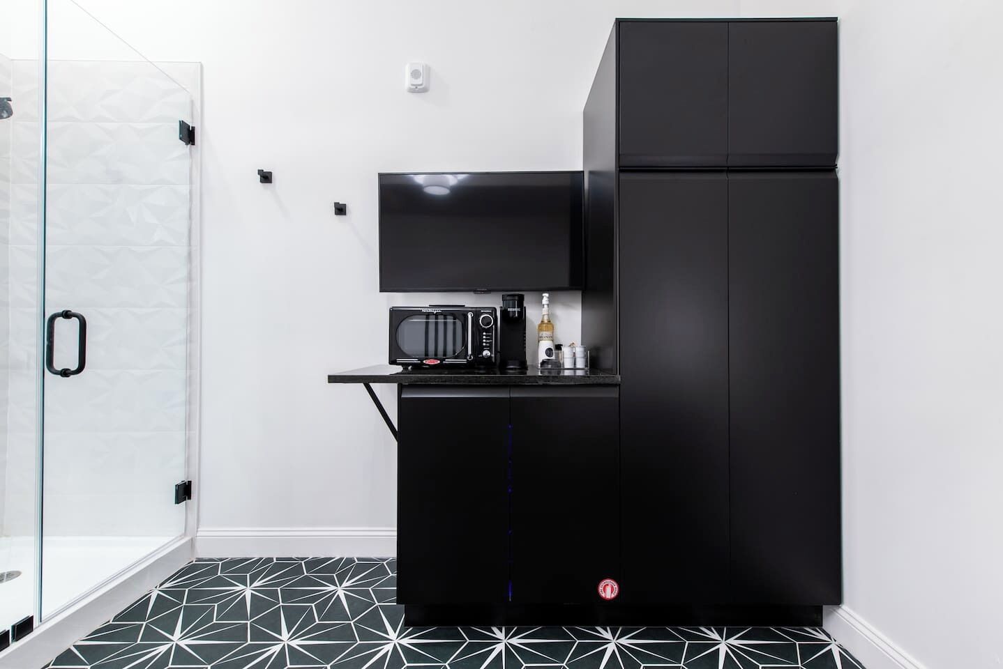 A compact kitchen with a black refrigerator, a microwave, and a small countertop.
