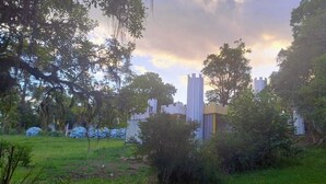 A building with a central tower and a smaller structure in front, surrounded by trees and greenery. - Medieval Village, your castle in Canela - Loft Lenister (Canela)