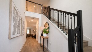 A staircase with black railings and wooden steps leading to an upper level. - High End Resort 7Beds Private Pool Gym Near Disney (Kissimmee)