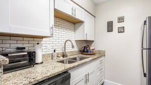 A kitchen with white cabinets, a granite countertop, a stainless steel sink, a toaster, and a dishwasher. - Walk to AT&T Stadium•Texas Live! & Globe Life (Arlington)