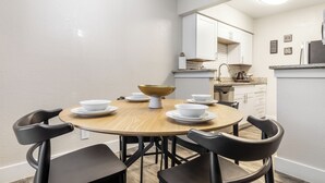 A dining area with a round table, black chairs, and a central bowl. - Walk to AT&T Stadium•Texas Live! & Globe Life (Arlington)