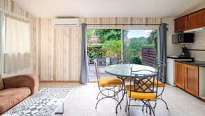 Une cuisine compacte avec un coin repas, un canapé et une vue sur la verdure.