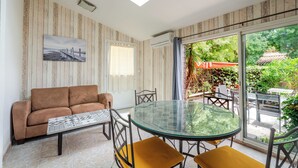 Une pièce avec une table en verre, un canapé et un tableau accroché au mur.