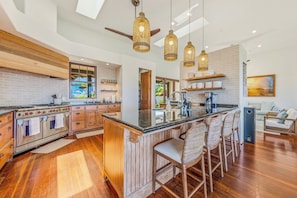 A spacious kitchen with a central island, wooden cabinets, and a built-in oven.