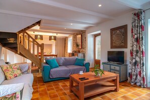 Ein Wohnzimmer mit Sofa, Couchtisch und Fernseher.