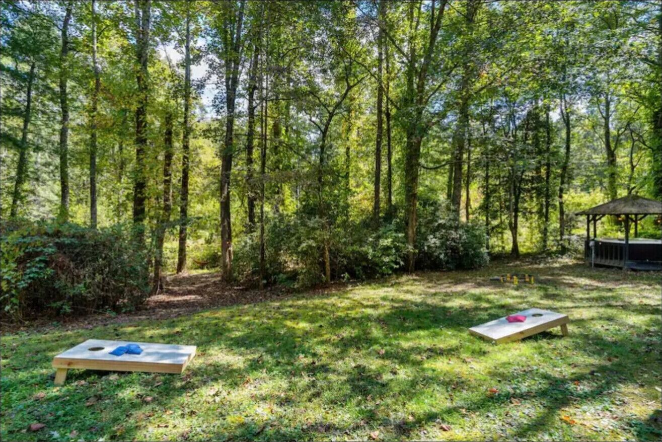 A forested area with two picnic tables and a gazebo.