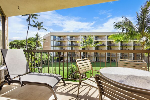 Unwind on your private balcony with garden views, tropical palms swaying above, and a perfect spot to sip your morning coffee surrounded by island charm. - One bedroom, two bath condo at the Maui Sunset. (Kihei)