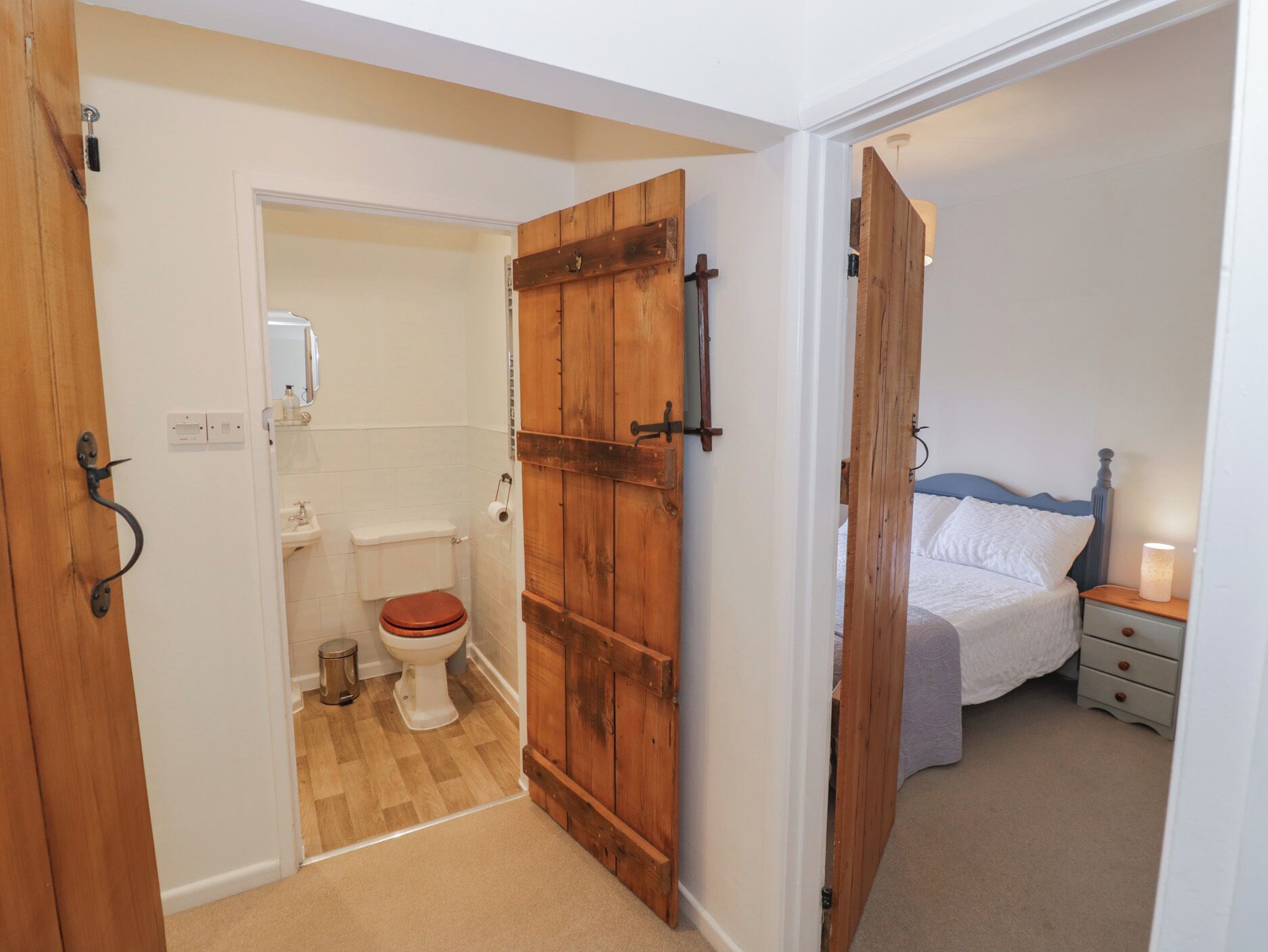 A bedroom with a bed, bedside table, and a nightstand.