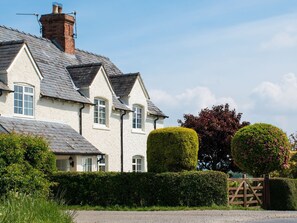A traditional house with a white exterior, a brick chimney, and a gravel driveway. - Glencoe Cottage (Broadway)