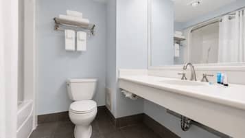A modern bathroom with a toilet, a sink with a mirror, and a towel rack.