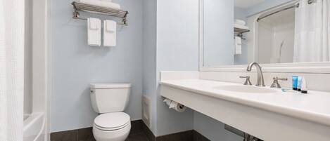 A modern bathroom with a toilet, a sink with a mirror, and a towel rack.