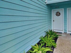 A building with teal siding and a door marked with the number 1105. - Turtle Baycation (Rockport)