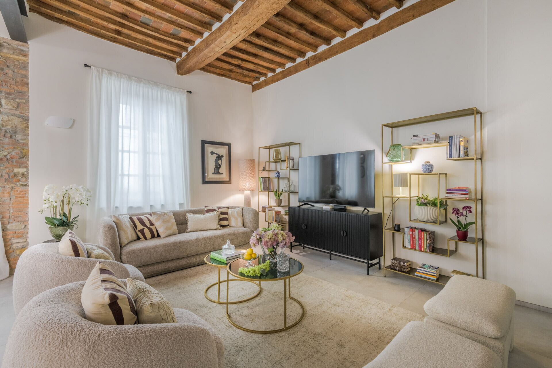 A living room with a sofa set, a coffee table, a TV, and a bookshelf.