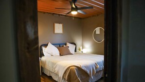 A bedroom with a bed, ceiling fan, and a wall-mounted mirror. - Lakeview LaFollette Retreat, Sleeps 10 - Game Room (LaFollette)