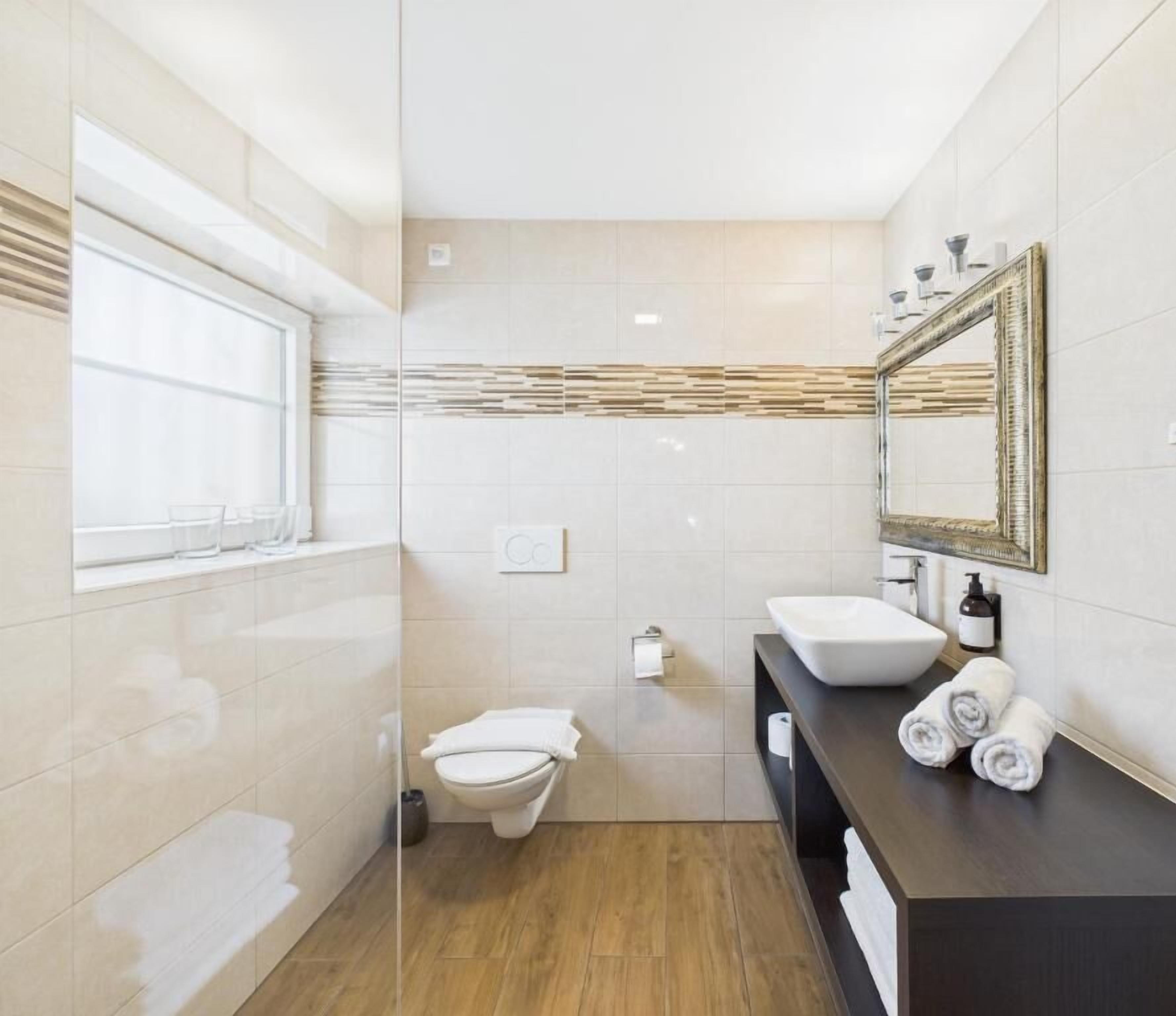 A modern bathroom with a toilet, sink, and shower area.