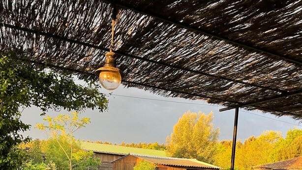 A wooden deck with outdoor furniture, a thatched roof, and a view of a grassy yard with buildings in the background. - Holiday Home 'Bienvenue À La Maison' with Private Terrace, Garden & Wi-Fi (Mézos)