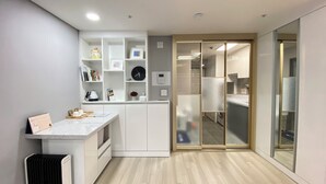 Une cuisine moderne avec des meubles blancs, un four à micro-ondes encastré et un calendrier posé sur le plan de travail.