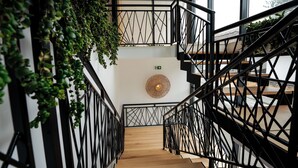 A staircase with black metal railings and wooden steps, surrounded by green plants. - Ayana Coral Bay Resort (Piatra-Olt)