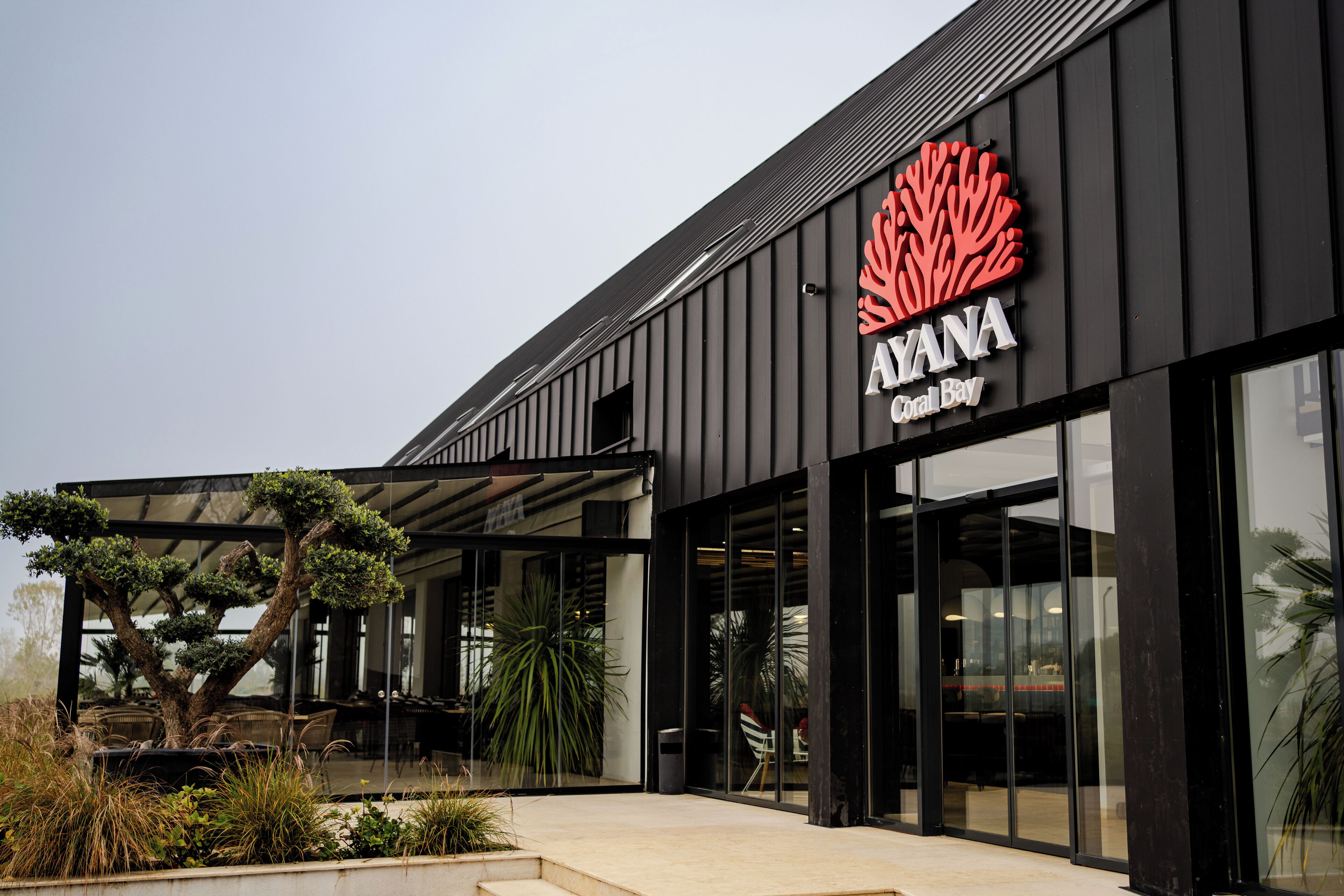 Un edificio moderno con un gran letrero que dice "AYANA Coral Bay".