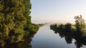 A calm river with dense greenery on both sides.