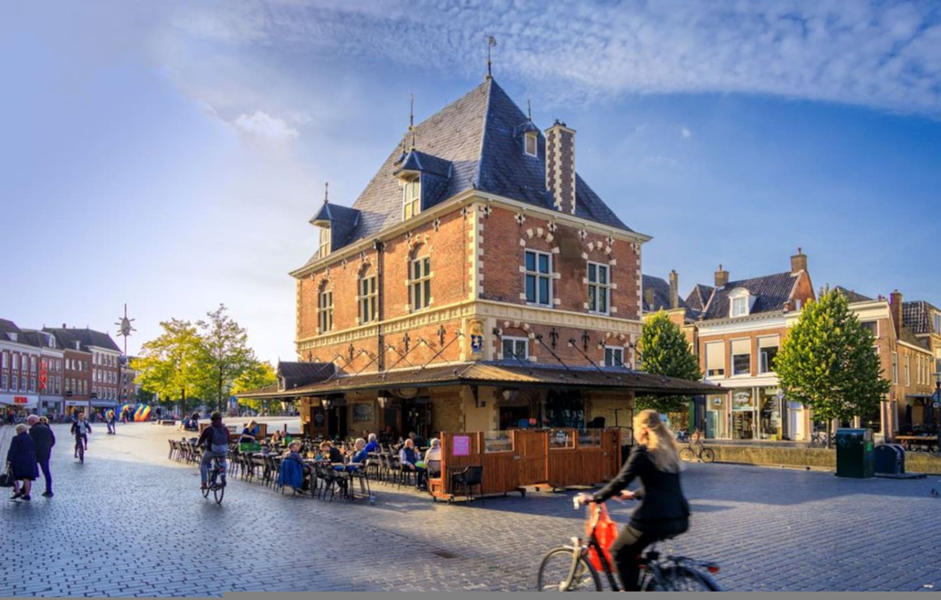 A historic building with a prominent tower and a covered outdoor seating area.
