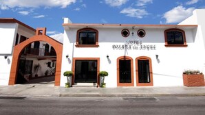 A white building with a sign reading "POSADA DEL ANGEL" and a red archway entrance. - Hotel Posada del Ángel (Mérida)