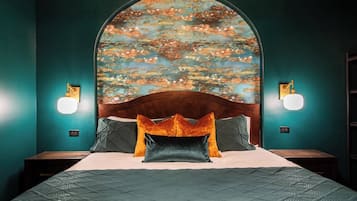 A bedroom with a large bed, two nightstands, and a wall-mounted light fixture.