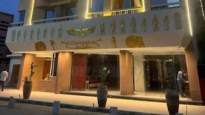 Ένα πολυώροφο ξενοδοχείο με μοντέρνο σχεδιασμό, που διαθέτει μπαλκόνια σε κάθε όροφο και μια επιβλητική είσοδο με μια επιγραφή που γράφει «Κλεοπάτρα».