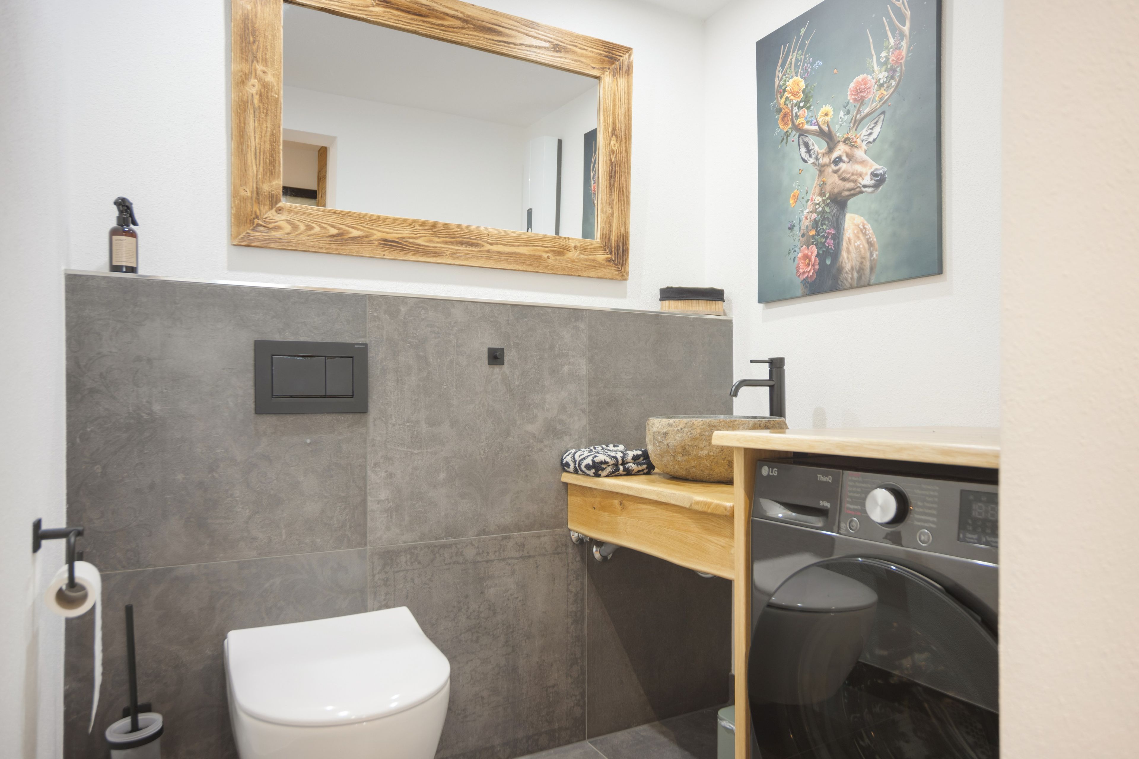 Une salle de bain moderne avec un meuble-lavabo en bois, des toilettes et un grand miroir.