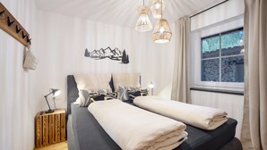 A bedroom with a bed, bedside lamps, a window with a view, and a wall-mounted artwork. - Allgäu 17 – Modern Alpine-Style Apartment (Leutkirch im Allgäu)