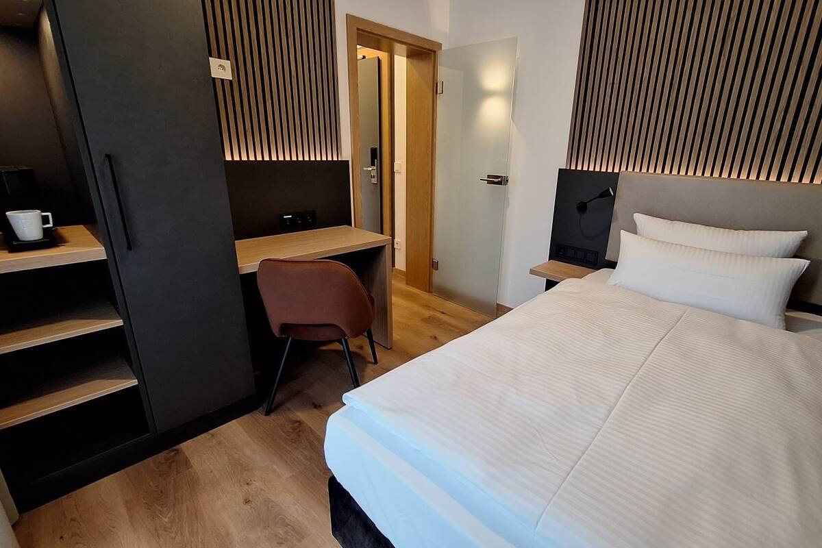 Une chambre d’hôtel comprenant un lit, un bureau, une chaise et une armoire.