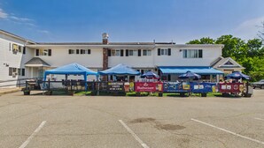A parking lot with a row of tents and a building with a sign that reads 'Wormtown'. - Rally Point Inn & Pub (Foxborough)