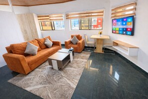 Apartamento superior, 1 quarto | Área de estar | TV