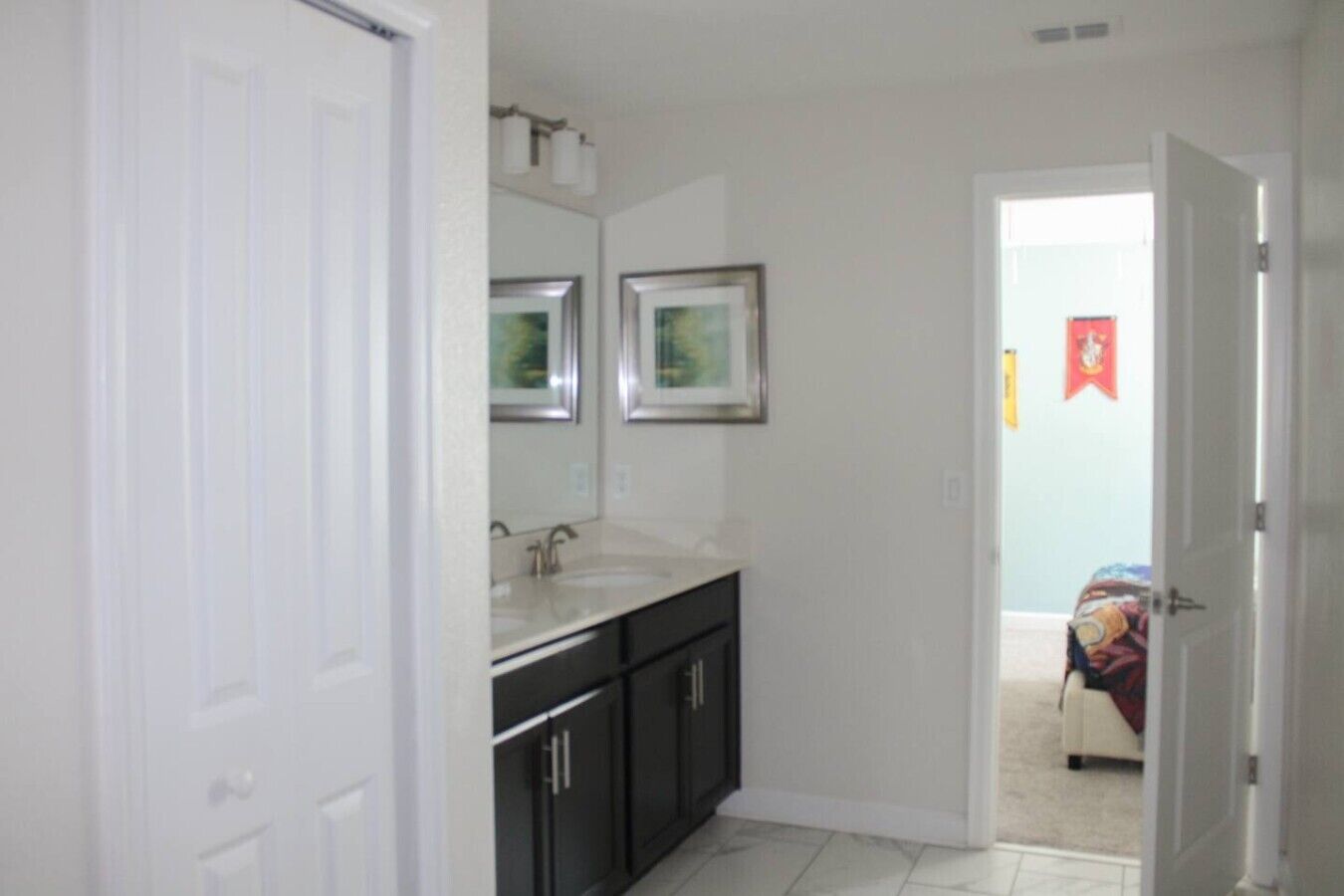 A bathroom with a white door, a sink, and a mirror.