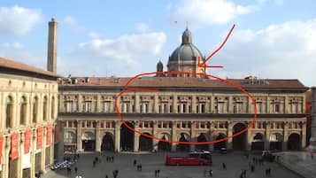 Una amplia plaza abierta con edificios históricos, una cúpula destacada y una torre alta.