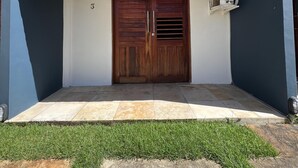 Un edificio con una porta in legno a due ante, un tetto in tegole e un piccolo condizionatore d'aria montato a parete.